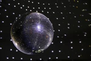 Shiny silver disco ball hanging from the ceiling photo