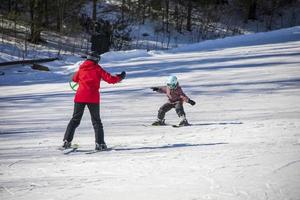 Little girl learning to ski on a ski slope photo