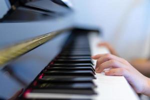 tocar el piano con la mano del niño shalow centrarse en el teclado y el dedo izquierdo