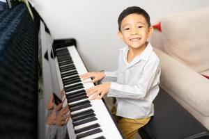 Boy happy while playing  his piano photo