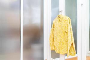 Long-sleeved shirt hanging in front of the wardrobe photo