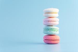 Sweet french macaroons cake pastel colored or macarons with vintage pastel blue colored background photo