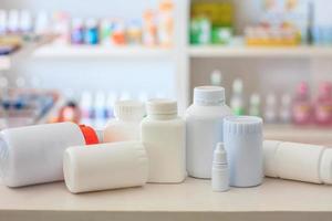 many medicine bottle with blur shelves of drug in the pharmacy drugstore background photo