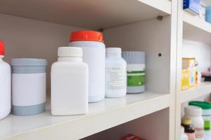 medicine bottles arranged on shelf at drugstore photo