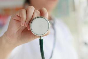 female doctor in white uniform holding stethoscope photo