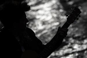 silueta de un niño con una guitarra foto