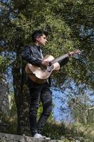 boy plays guitar in nature photo