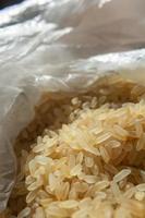 Dry rice in a plastic bag close-up. Vertical orientation of the photo. Food preparation. photo