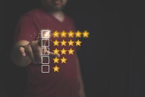 Customer review feedback survey, satisfaction ranking high. A man give rating to service experience on online application. Customer can evaluate of service leading to reputation ranking of business.
