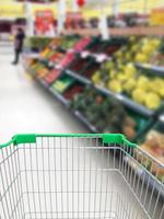 comprar algunas frutas y verduras en el supermercado con carrito de compras foto