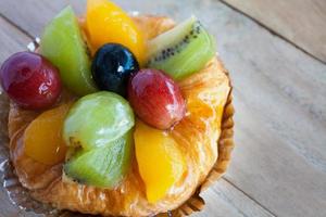 cerrar pastelería danesa con fruta en la mesa de madera foto