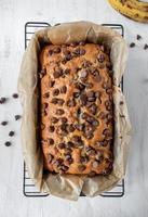 baked chocolate chip banana bread loaf on wax paper flat lay