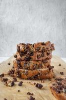 slices of chocolate chip banana bread loaf stacked on wax paper photo