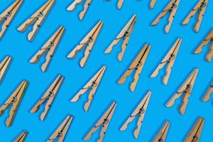 opened clothespins laid out in pattern on vibrant blue background