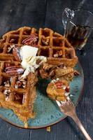 pumpkin waffles with pecans topped with butter and syrup flat lay