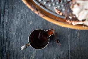 jarabe de chocolate en un pequeño recipiente plateado con goteo sobre una mesa de madera foto