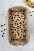 banana bread mixture with chocolate chips in baking pan flat lay photo