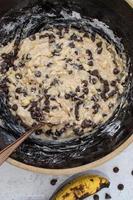 banana bread mixture with chocolate chips in large rustic bowl flat lay photo