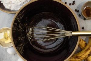 Making banana bread with large rustic bowl and ingredients flat lay photo