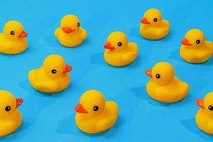 yellow rubber ducks in a pattern on blue background with copy space photo