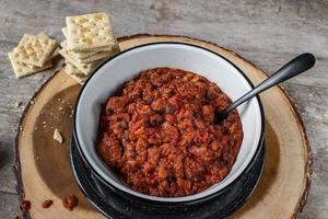 warm bowl of chili and beans with crackers in rustic setting photo