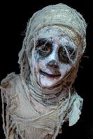 studio shot portrait of young boy in costume dressed as a Halloween, cosplay of scary mummy pose on isolated black background photo