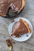 sliced chocolate pudding pie with rustic crust flat lay photo