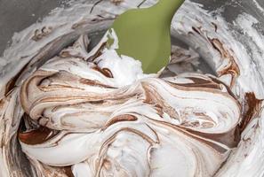 Meringue and chocolate swirl in mixing bowl with spatula photo