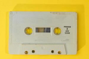 old retro cassette tape with grunge label on yellow background flat lay