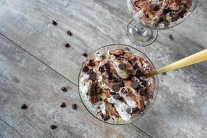 postre de pudín de vainilla y chocolate rociado con caramelo y chispas de chocolate plano foto