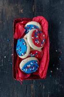 Festive Fourth of July cookies with star sprinkles on wooden table
