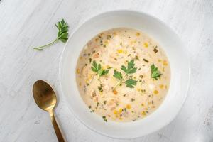 sopa cremosa de sopa de mariscos con maíz y perejil plano foto