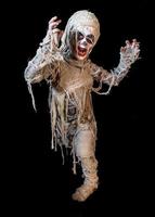 studio shot portrait of young boy in costume dressed as a Halloween, cosplay of scary mummy pose on isolated black background photo
