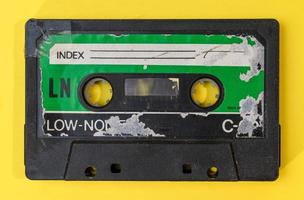 old retro cassette tape with grunge label on yellow background flat lay photo