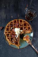 pumpkin waffles with pecans topped with butter and syrup flat lay photo