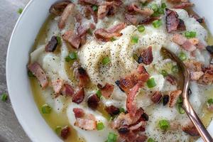 homemade bowl of mashed potatoes with bacon and green onions with butter flat lay photo