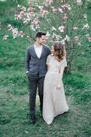Sunshine portrait of happy bride and groom outdoor in nature location at sunset. Warm summertime