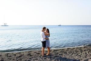 Young beautiful couple kissing on sea background. photo