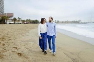 A loving couple, man and woman enjoying summer vacation on a tropical paradise beach with clear sea ocean water and scenic photo