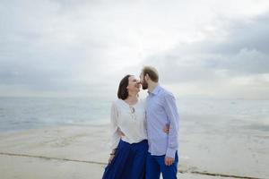 A loving couple, man and woman enjoying summer vacation on a tropical paradise beach with clear sea ocean water and scenic photo