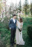 Sunshine portrait of happy bride and groom outdoor in nature location at sunset. Warm summertime photo