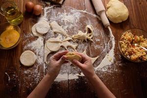 Raw homemade pies on a wooden background. photo