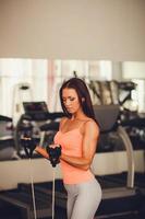 Beautiful young woman doing exercise at the gym. athletic build photo