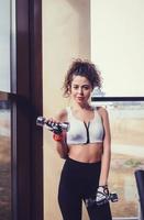 woman does the exercises with dumbbells photo