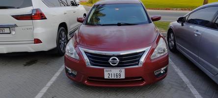 dubai, emiratos árabes unidos, abril de 2022, vista pintoresca del coche rojo nissan altima en un cielo azul soleado foto