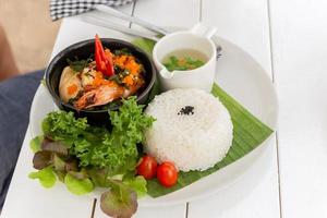 El famoso plato tailandés pad kra pao stream arroz con langostinos y sopa de verduras. foto