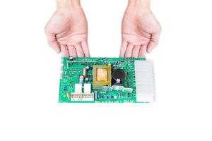 mano que muestra la placa de circuito electrónico aislada en fondo blanco.