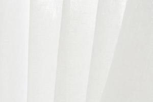 Close up white linen curtain background texture hanging by the window. photo