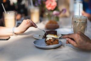 Hand with spoon getting ready to taste homemade carrot cake in a cafe. photo