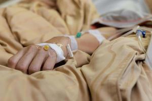 Focus on the hand of a patient lying in hospital ward. photo